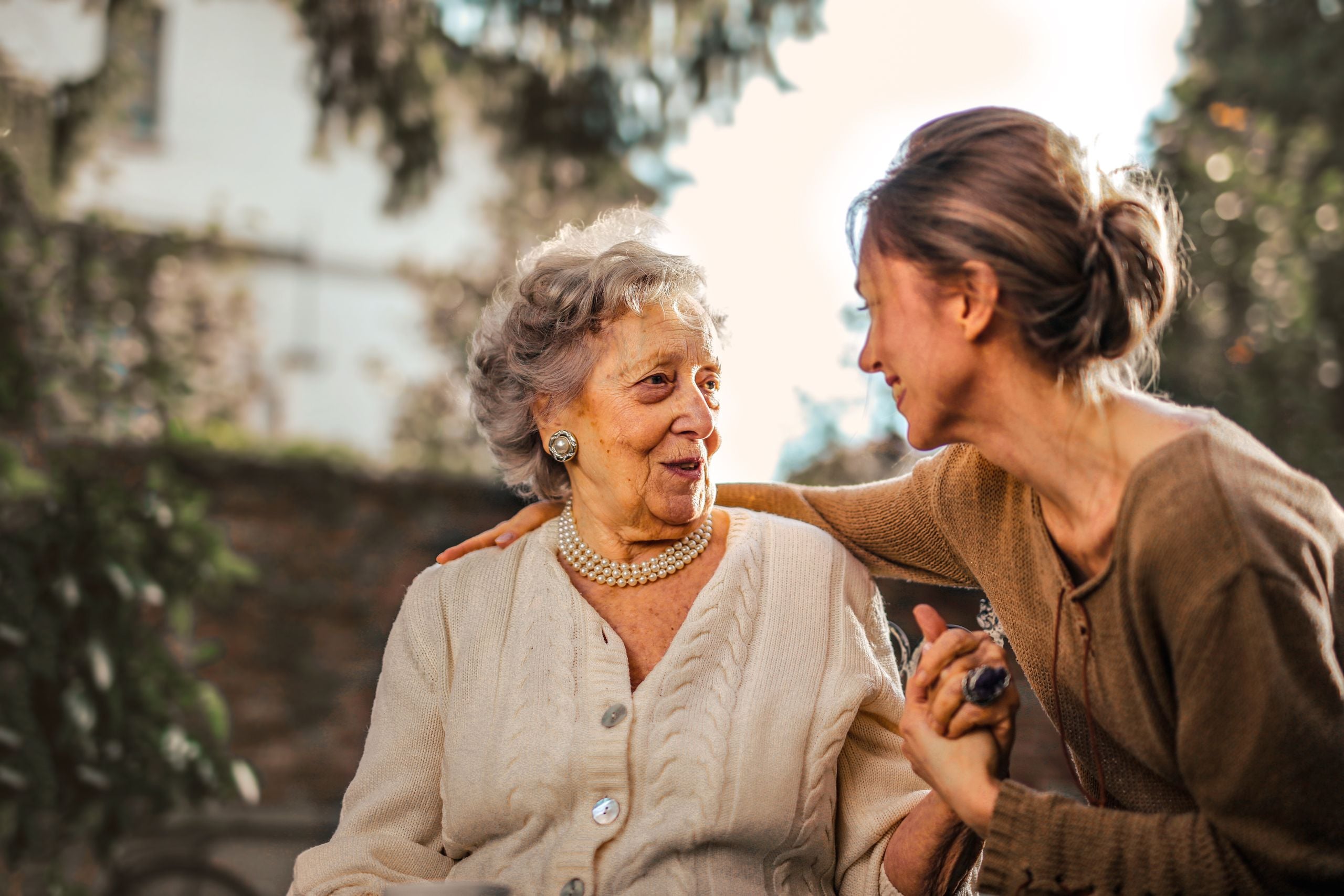 in-home-care-Ladue-MO-2 caregiver sharing a warm moment with an older woman outdoors in Ladue, MO