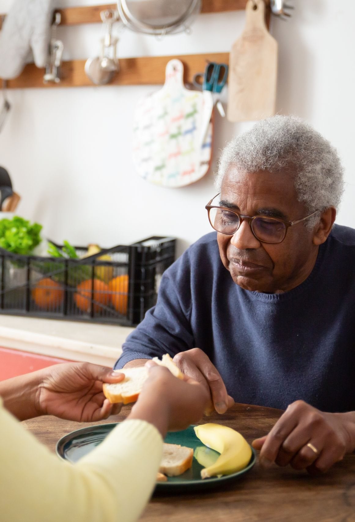 in-home-care-Ladue-MO-3-tall caregiver helping an older man with a meal at home in Ladue, MO
